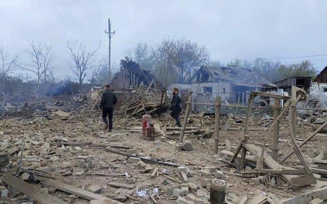 Dos hombres caminan entre los escombros del distrito de Pavlohrad, atacado por los misiles rusos.