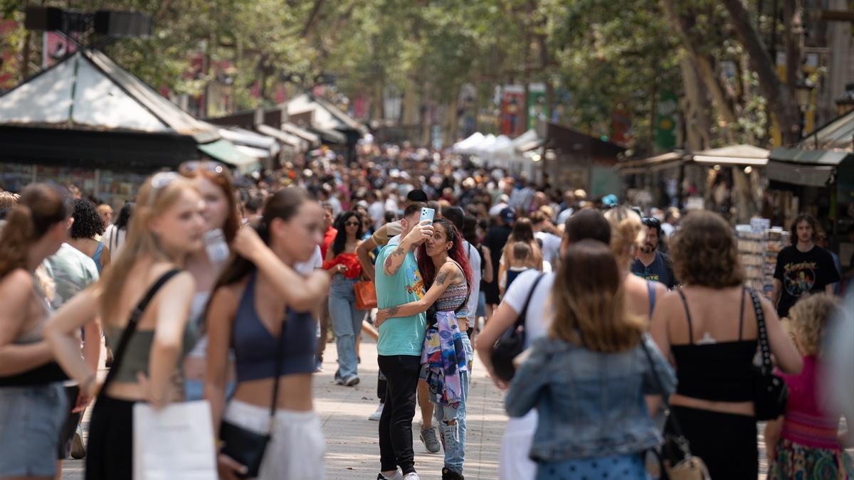 Varias personas pasean por Las Ramblas.