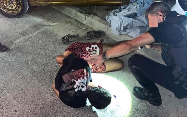 Un agente de la Policía Local de El Campello (Alicante) junto al conductor temerario detenido.