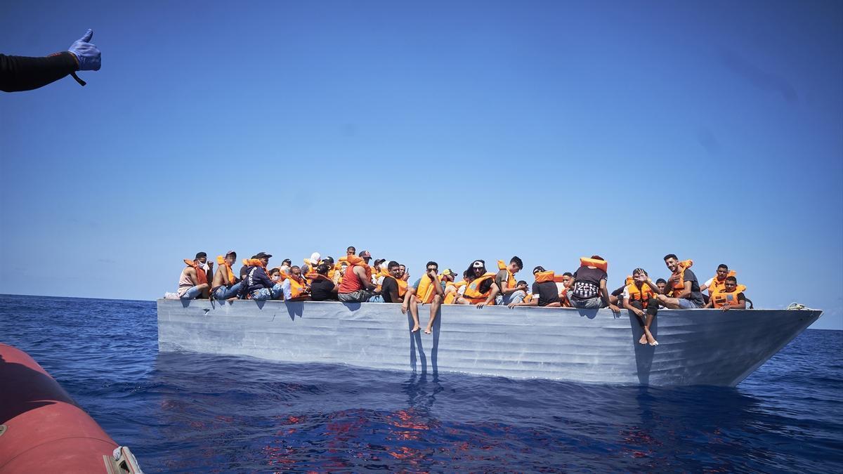 Varios inmigrantes a bordo de una patera cerca de la isla de Lampedusa en una foto de archivo.