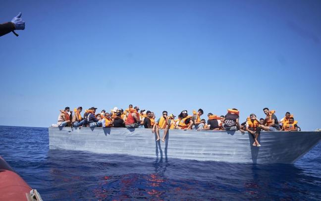 Varios inmigrantes a bordo de una patera cerca de la isla de Lampedusa en una foto de archivo.