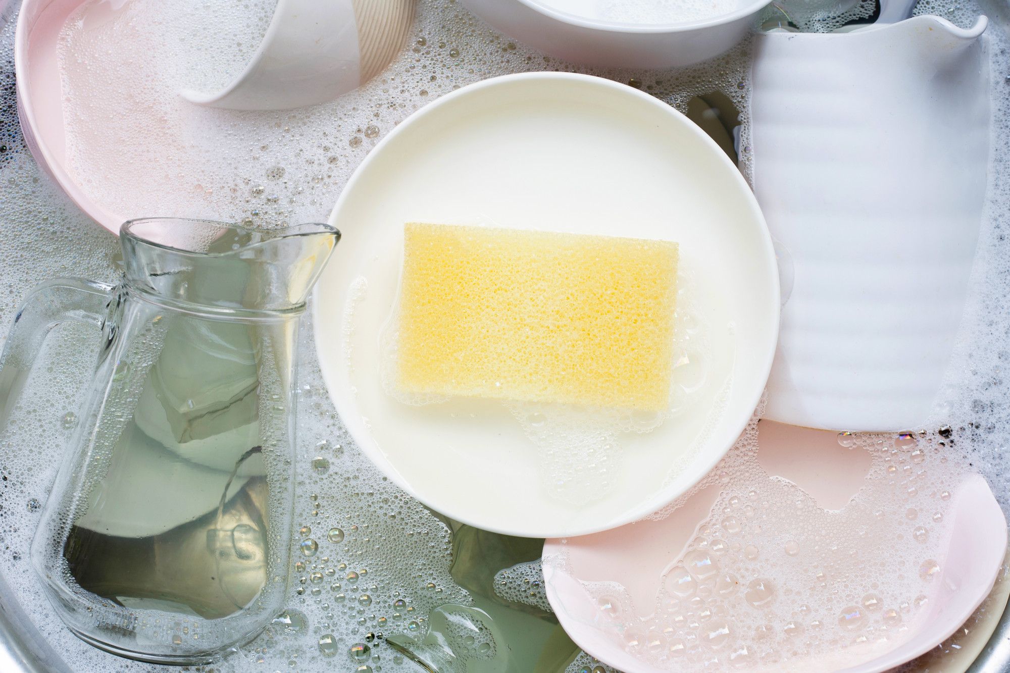 Vajilla a remojo en agua y jabón en una fregadera.