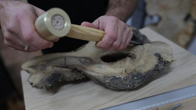 Manos habilidosas trabajando la madera para convertirla en una pieza artesanal.
