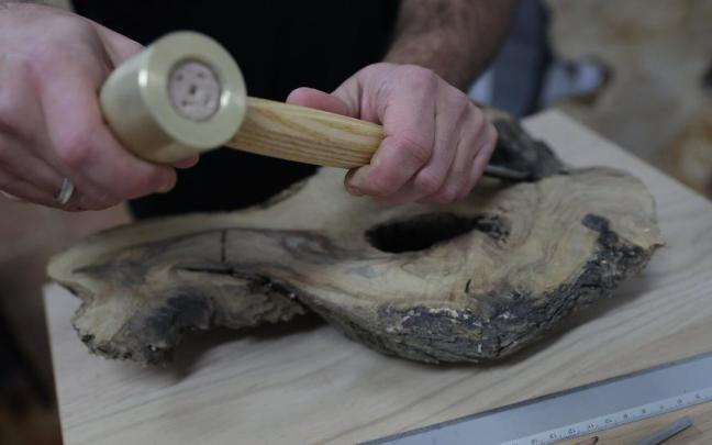 Manos habilidosas trabajando la madera para convertirla en una pieza artesanal.