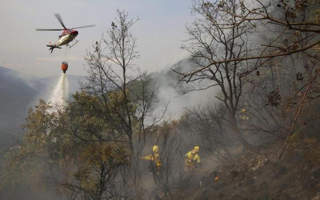 Varios bomberos forestales durante las labores de extinción del incendio de Llamas de Cabrera, en León.