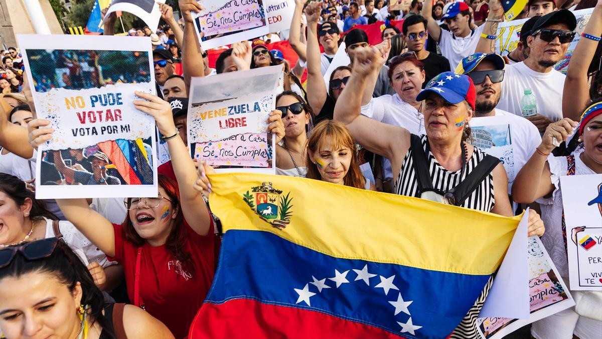 Manifestantes con pancartas durante una protesta en apoyo a la oposición venezolana.