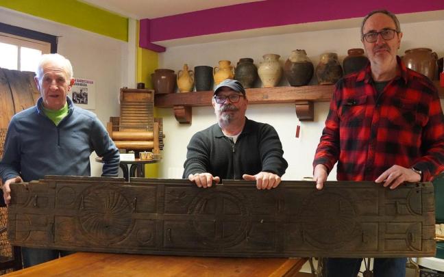Miembros de Burdina sujetan la tabla para colgar los productos del cerdo / Aitziber Muga Miembros de Burdina sujetan la tabla para colgar los productos del cerdo