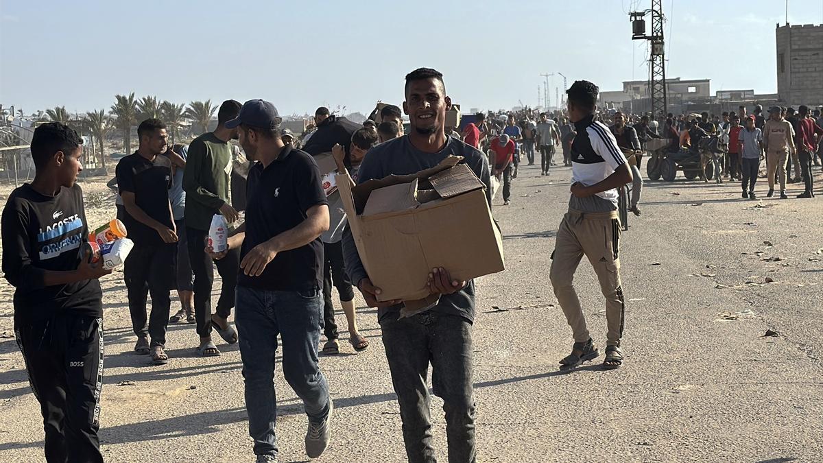 Grupos de palestinos recogen paquetes de ayuda humanitaria en uno de los puestos de la polémica Fundación Humanitaria para Gaza.