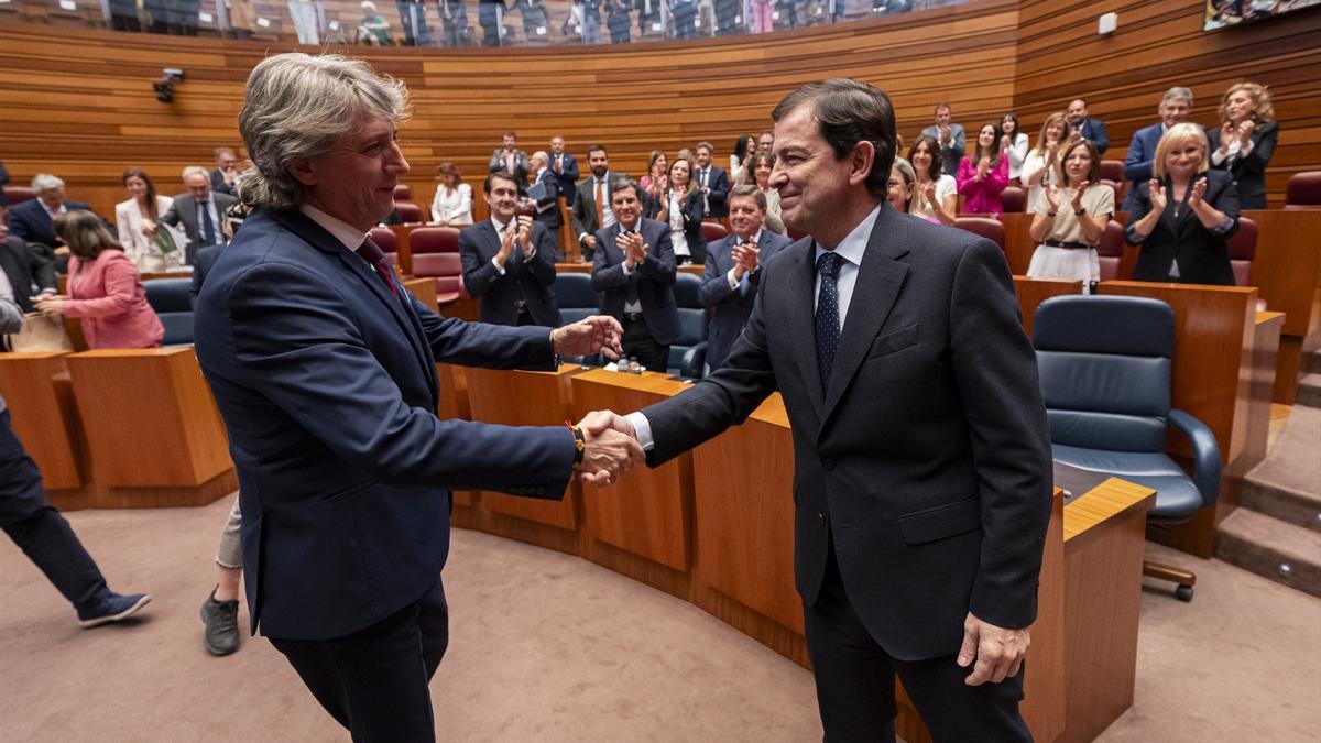 El presidente de la Junta de Castilla y León, Alfonso Fernández Mañueco (d), es felicitado por el secretario general del PSOE de Castilla y León, Carlos Martínez (i),.