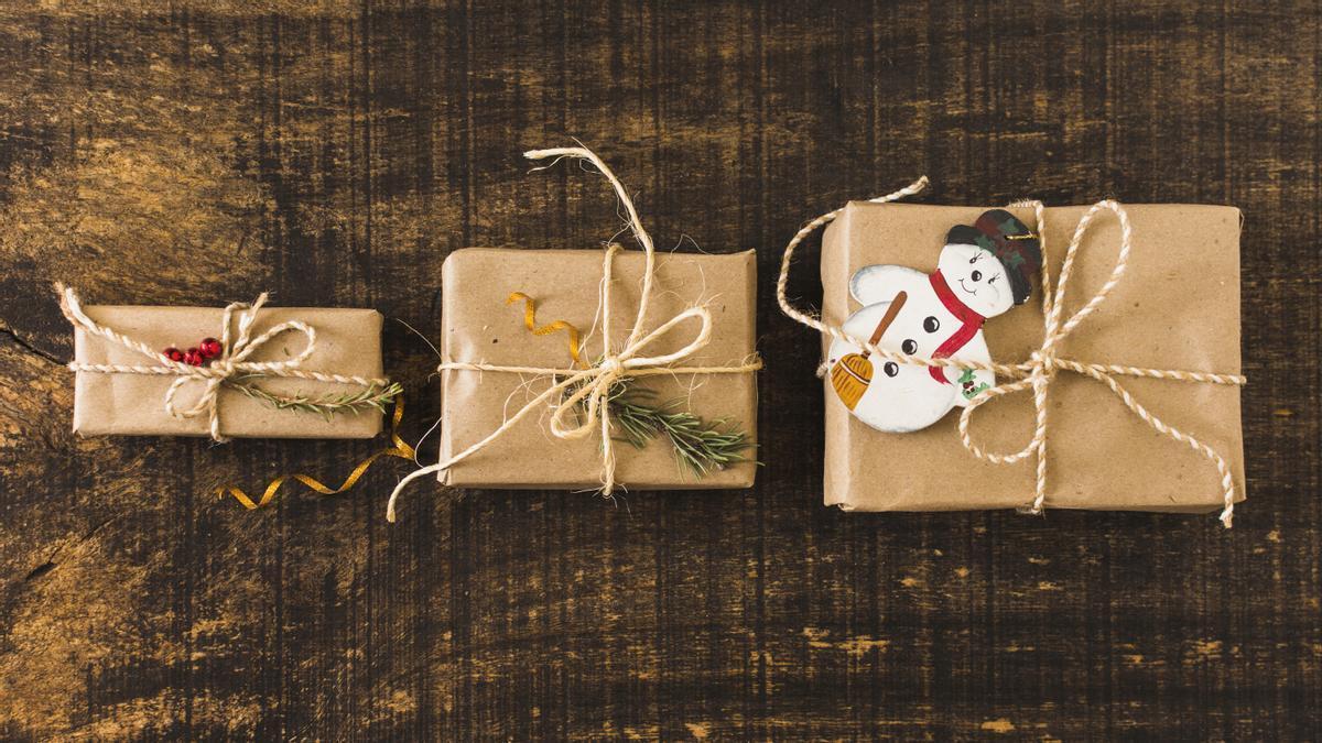 Regalos envueltos con papel kraft, cuerda y pequeños elementos decorativos