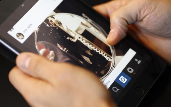 Un menor accede a una red social con su teléfono móvil.