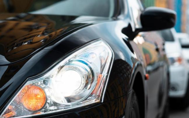 Un coche, con las luces encendidas durante el día. Un coche, con las luces encendidas durante el día.
