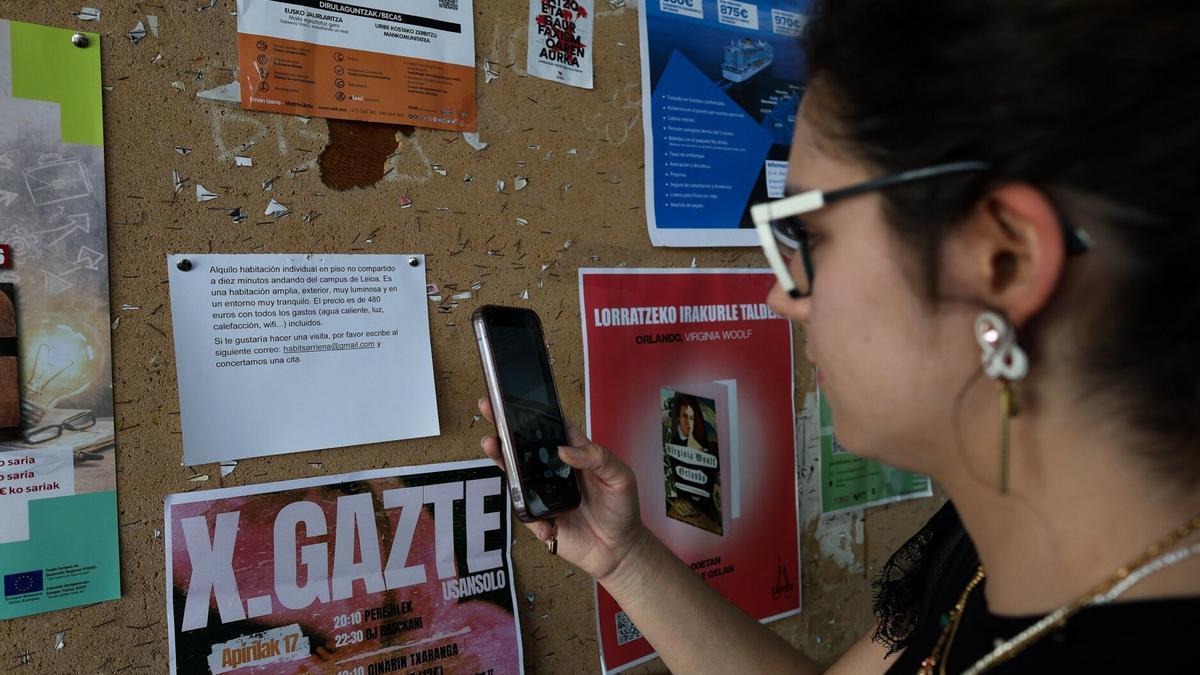 Una estudiante consulta un anuncio inmobiliario en la EHU.