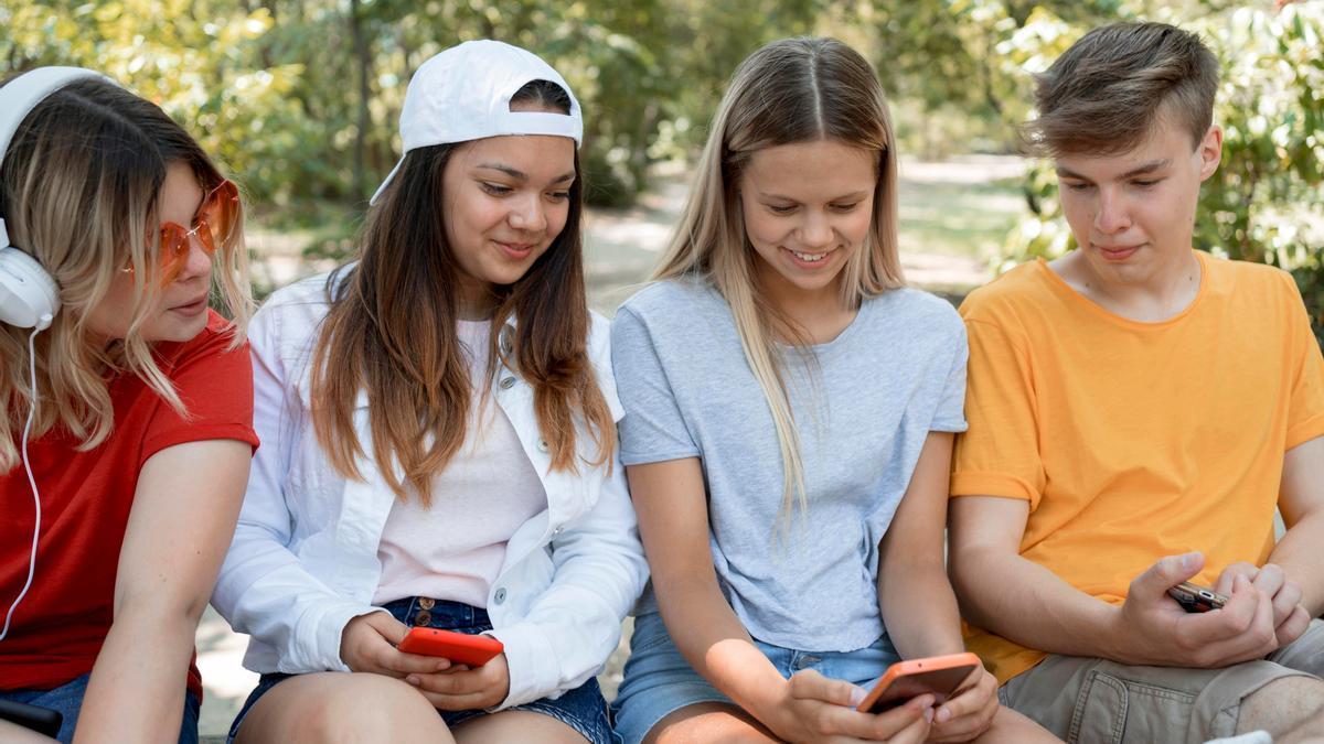 Jóvenes de la Generación Z pegados a sus teléfonos móviles.