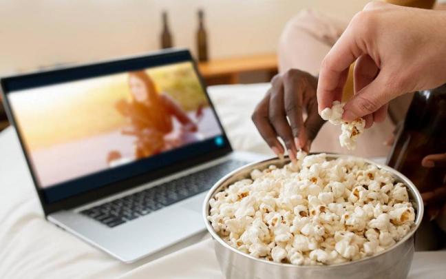Personas comiendo palomitas, en una imagen de archivo.
