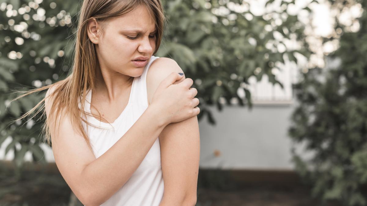 Mujer con picadura de mosquito en el brazo.