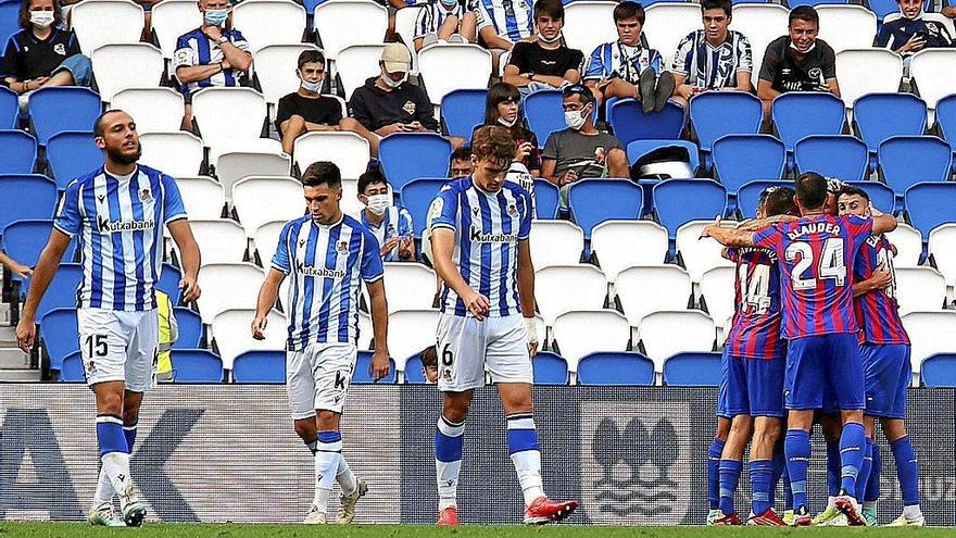 Las caras de resignación de Blasco, Alkain y Urko contrastan con la alegría de los los jugadores del Eibar, que, de fondo, celebran uno de los goles anotados en la tarde de ayer en Anoeta. Noticias de Gipuzkoa