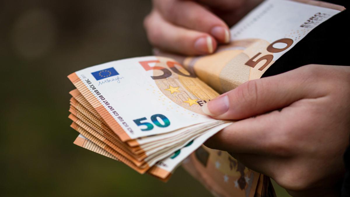 Una mujerer sostiene varios billetes.