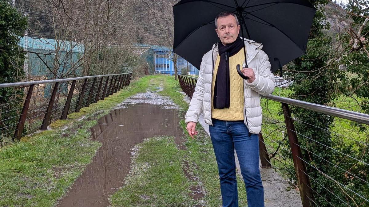 El portavoz jeltzale en el Ayuntamiento de Zestoa, Garikoitz Mendizabal, mostrando el estado de la Vía Verde entre el Balnearios y el casco urbano.