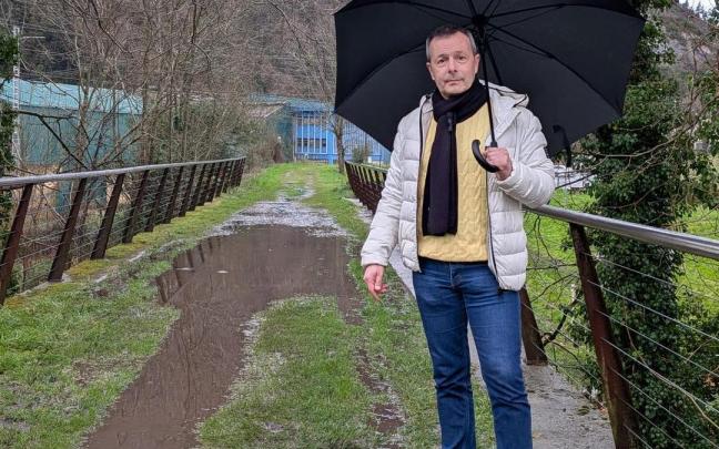 El portavoz jeltzale en el Ayuntamiento de Zestoa, Garikoitz Mendizabal, mostrando el estado de la Vía Verde entre el Balnearios y el casco urbano.