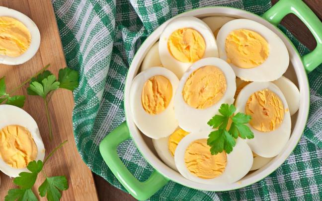 Huevos cocidos partidos por la mitad en un bol decorado con hojas de perejil. Huevos cocidos partidos por la mitad en un bol decorado con hojas de perejil.