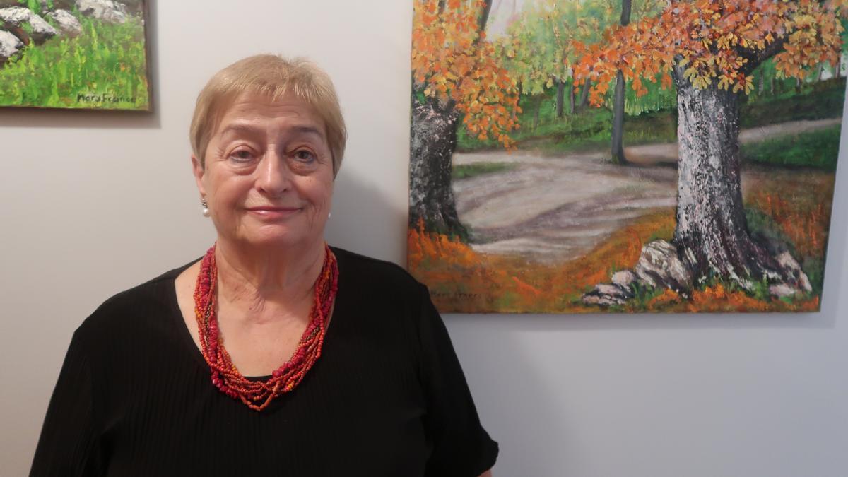 La pintora Mary Franco, antes dos de sus cuadros.