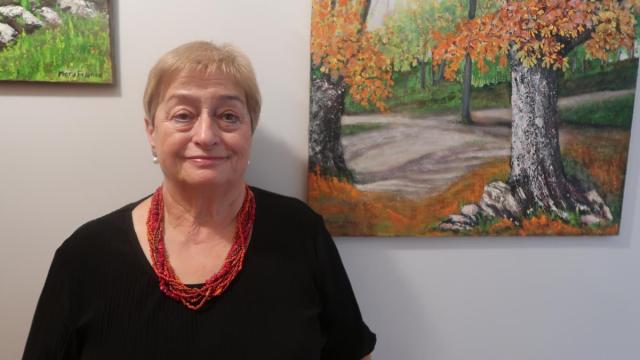 La pintora Mary Franco, antes dos de sus cuadros.