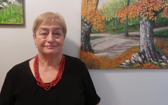 La pintora Mary Franco, antes dos de sus cuadros.