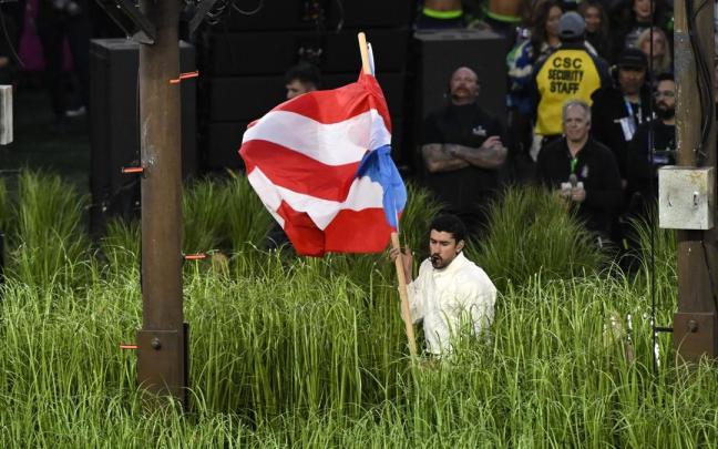El puertorriqueño Bad Bunny porta una bandera de su país durante su actuación en el intermedio de la SuperBowl