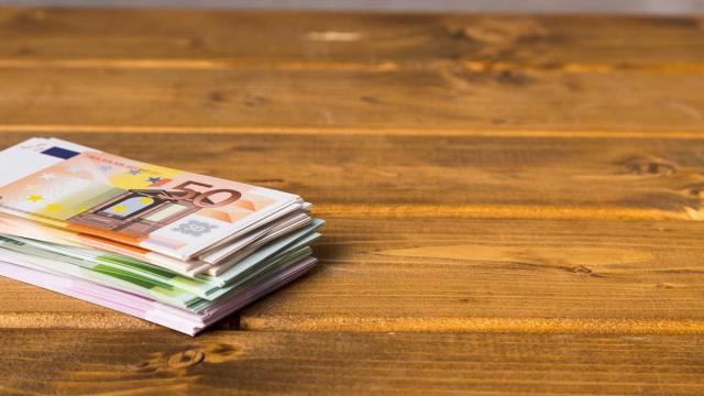 Taco de billetes de euro sobre una mesa de madera. Taco de billetes de euro sobre una mesa de madera.