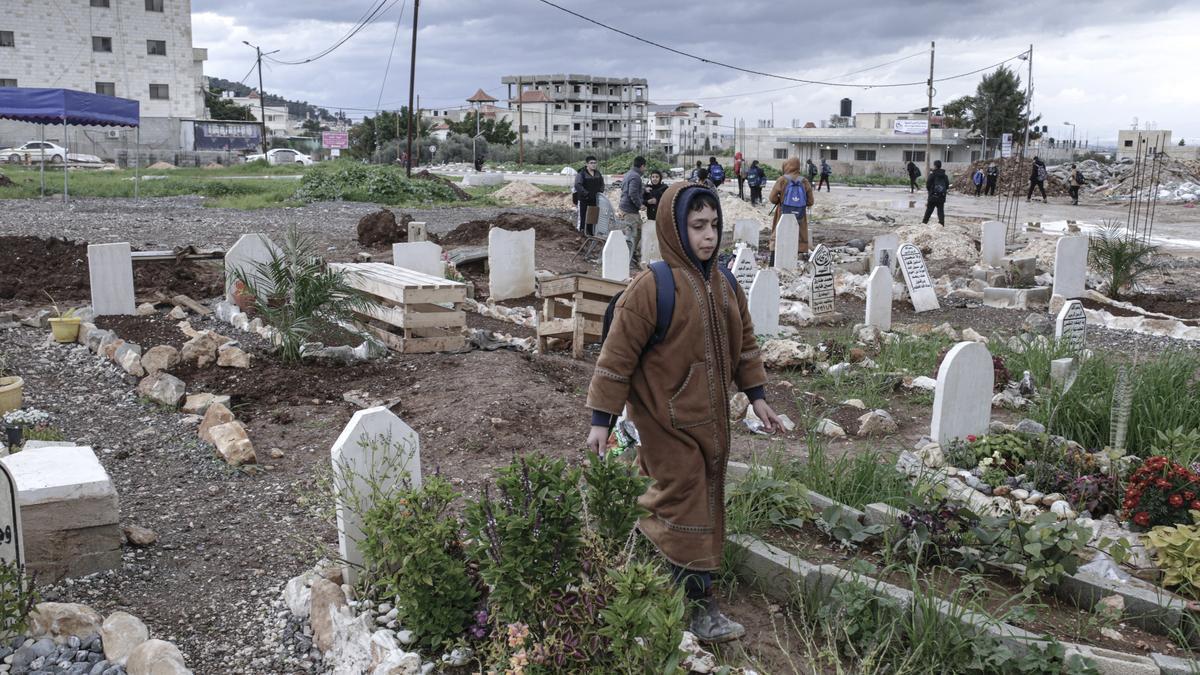 Niños de un colegio próximo a Yenín pasean por los aledaños de un cementerio, Cisjordania.