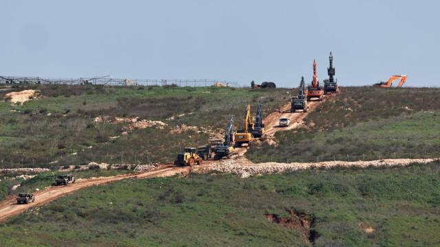 Excavadoras israelíes, escoltadas por vehículos militares, se desplazan por el lado libanés de la frontera