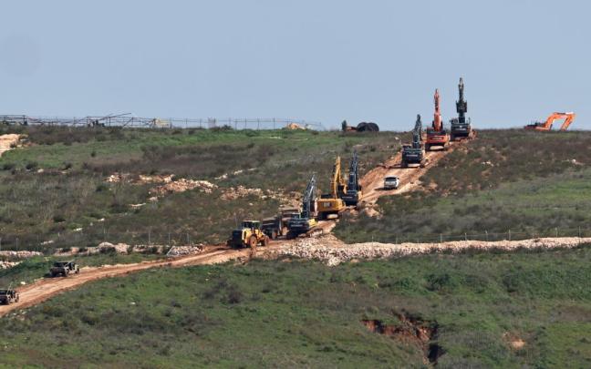 Excavadoras israelíes, escoltadas por vehículos militares, se desplazan por el lado libanés de la frontera