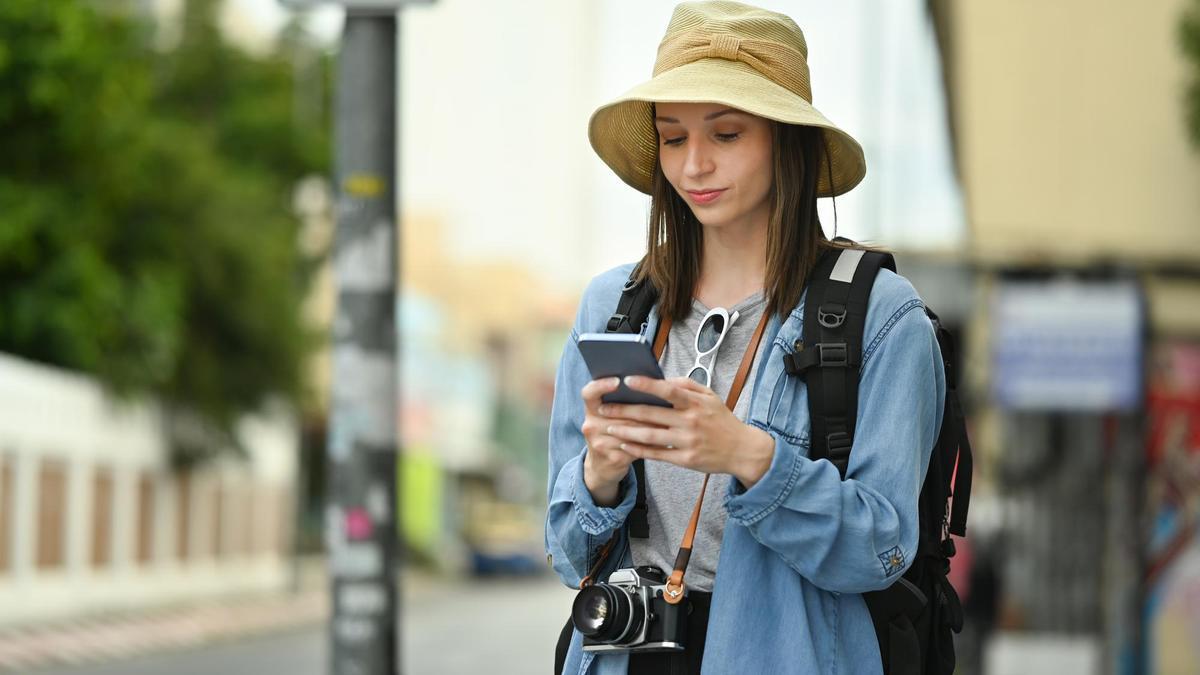 Una turista chatea con su móvil durante un viaje.