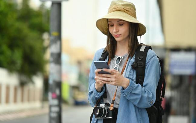 Una turista chatea con su móvil durante un viaje. Una turista chatea con su móvil durante un viaje.