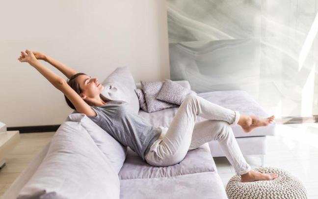 Chica disfruta de un momento de relax en el sofá.
