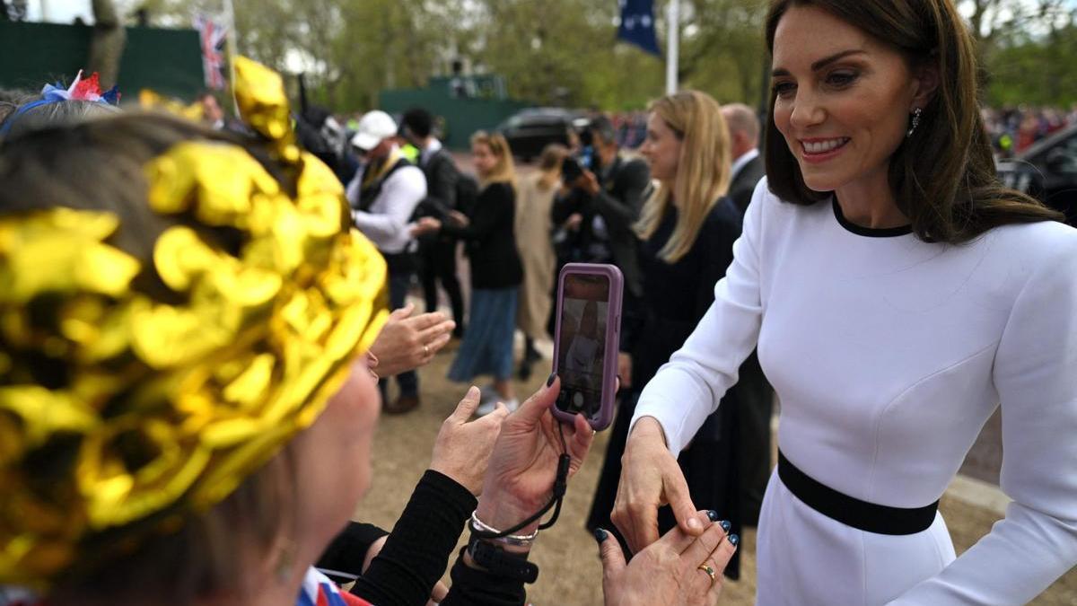 La duquesa de Cambridge saluda a los congregados ante el Palacio de Buckingham.
