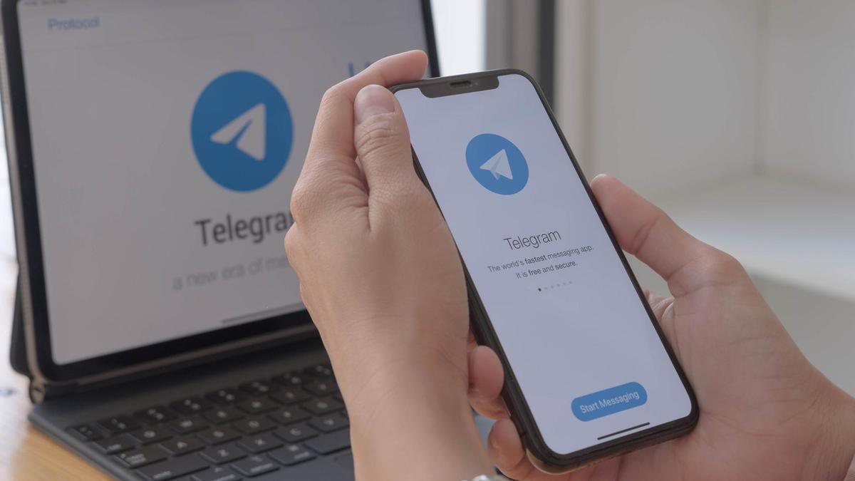 Logotipo de Telegram en un teléfono móvil y en un ordenador portátil.
