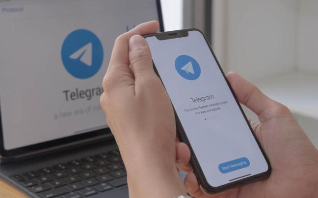 Logotipo de Telegram en un teléfono móvil y en un ordenador portátil.