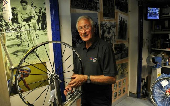 Luis Zubero posa en su negocio de bicicletas delante de una foto en la que persigue a Merckx.