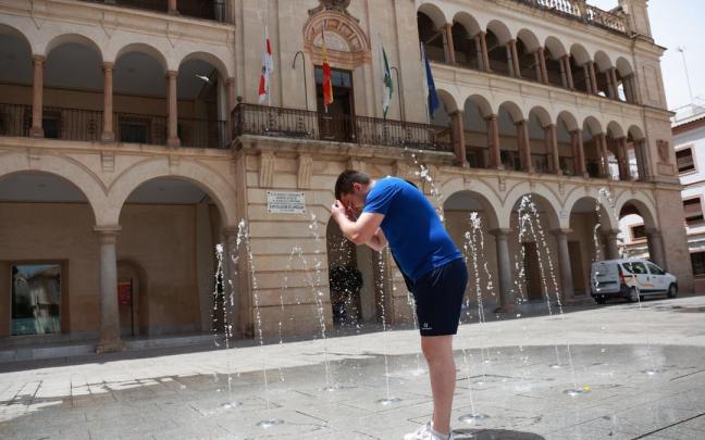 Un joven se refresca en plena ola de calor.