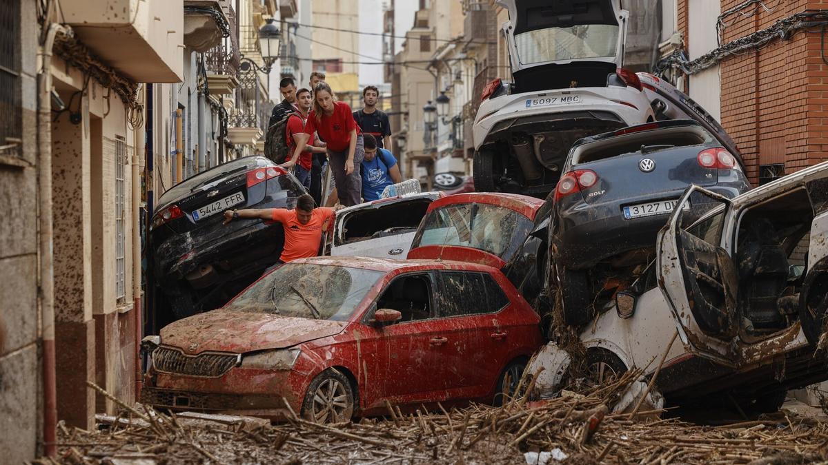 Coches apilados en una calle de Paiporta (Valencia), tras el paso de la dana de 2024.