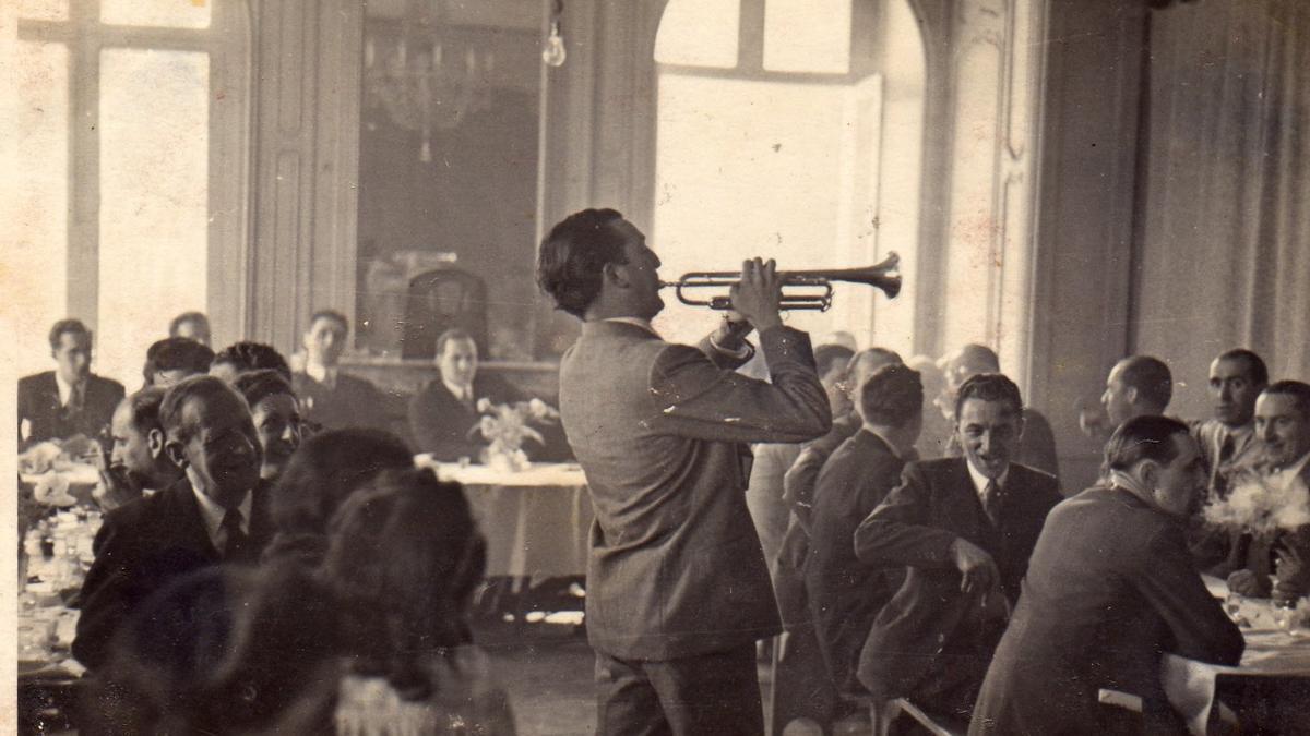 Txomin Letamendi tocando la trompeta en París a finales de los años 30; al fondo, sentado y escuchando, el lehendakari José Antonio Agirre.