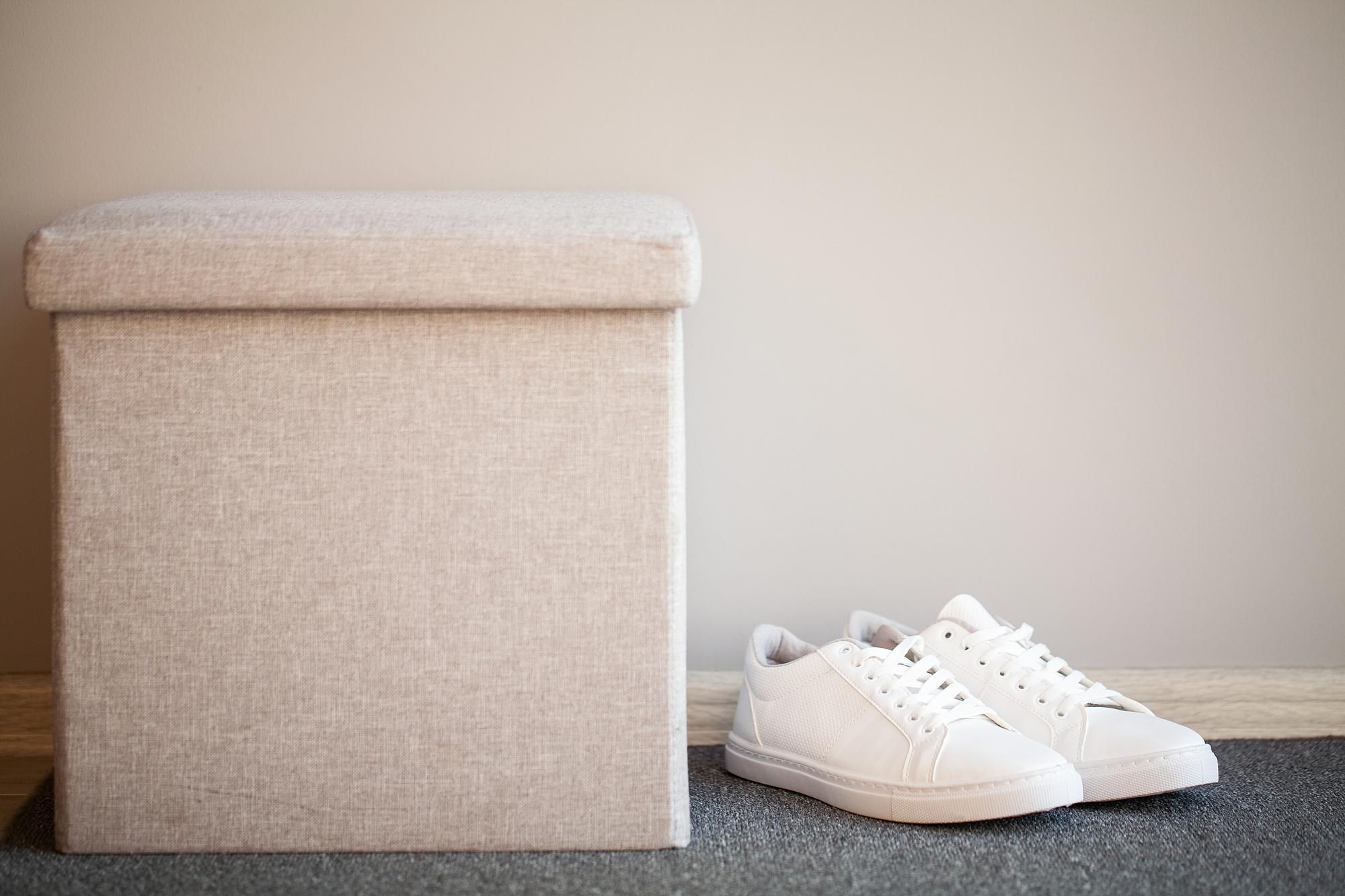 Un par de deportivas junto a un puff de almacenaje.