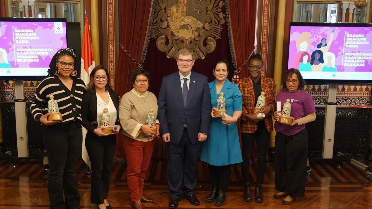 Juan Mari Aburto posa esta mañana en compañia de las seis mujeres migrantes reconocidas. / BORJA GUERRERO