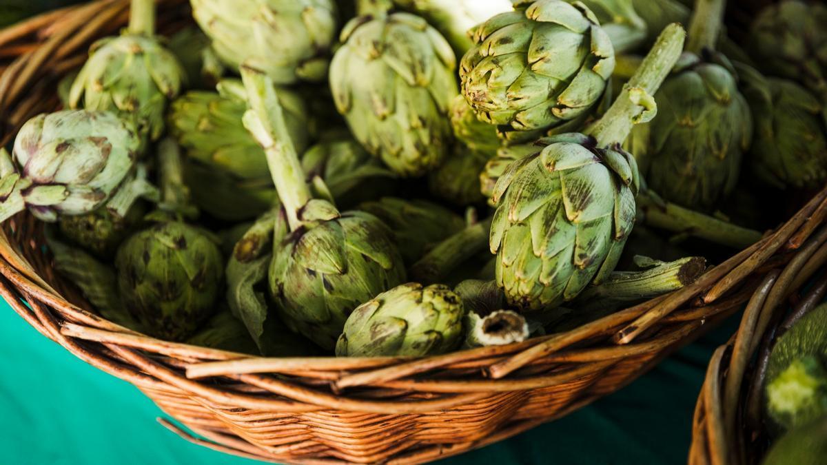 Una cesta de alcachofas en un puesto del mercado.
