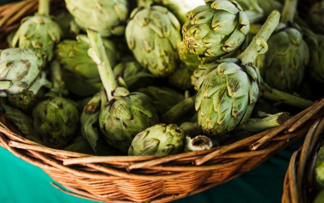 Una cesta de alcachofas en un puesto del mercado.