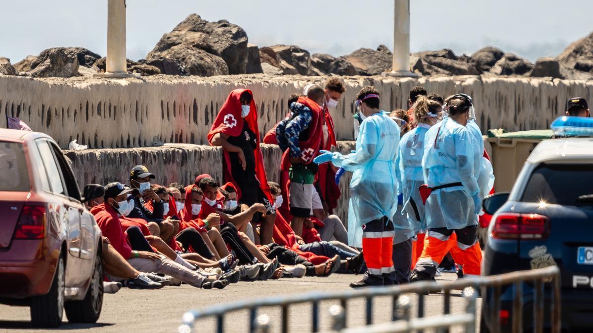 Varios trabajadores de la Cruz Roja con algunos de los 34 migrantes que han sido rescatados por Salvamento Marítimo