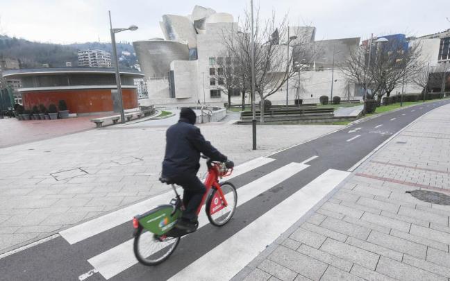 Un hombre pasea en bicicleta con el Guggenheim de fondo. Un hombre pasea en bicicleta con el Guggenheim de fondo.
