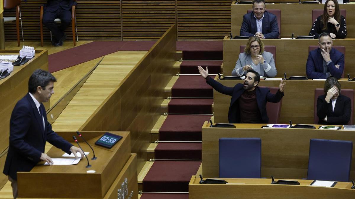 José Muñoz (c) realiza un gesto durante la intervención en Les Corts Valencianes del president de la Generalitat, Carlos Mazón (i).